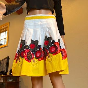 Pura Vida cotton skirt with front pleats and floral appliqué in yellow and reds